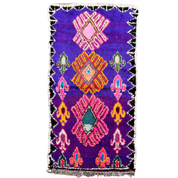 Tapis Marocain Berbere violet avec de motifsgéométriques roses et jaunes.