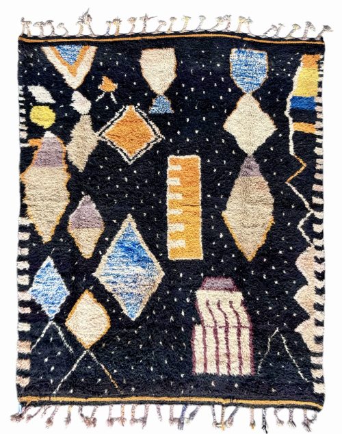 tapis berbère à motifs géométriques colorés sur fond noir, avec franges aux extrémités