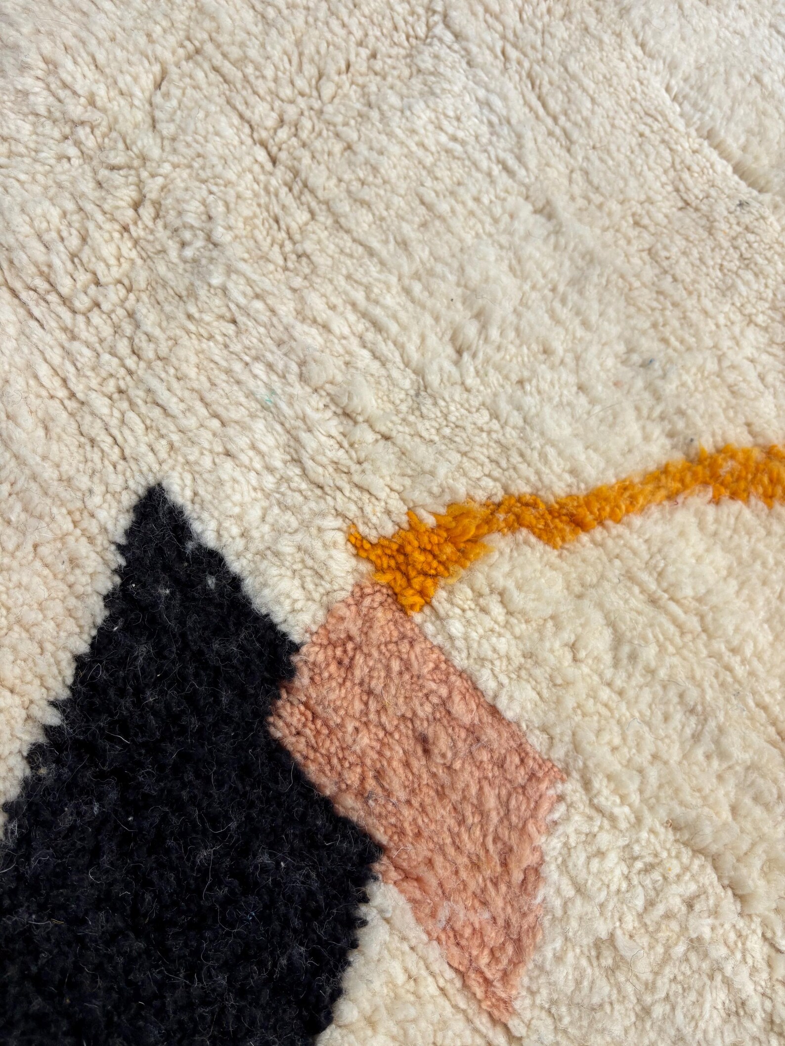 il_1588xN7163606216_g706jpg - Les Losanges Close-up of a cream shag carpet with a black triangular shape and an orange zigzag line pattern.